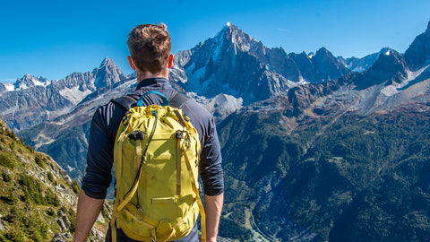 hiker with yellow pack on the tour du mont blanc abobe les Houches
